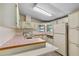 Classic kitchen featuring white cabinets, tile countertops, and vintage appliances for a nostalgic feel at 1855 Stacey Dr, Mount Dora, FL 32757