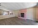 Spacious living room with a pink brick fireplace, mirrored wall, and wood-look flooring at 1855 Stacey Dr, Mount Dora, FL 32757