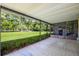 Spacious covered patio with views of lush green lawn and mature trees, perfect for outdoor relaxation at 1855 Stacey Dr, Mount Dora, FL 32757
