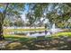 Picturesque pond with fountain and bench seating under mature trees at 1855 Stacey Dr, Mount Dora, FL 32757