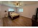 Comfortable bedroom featuring wood floors, ceiling fan, and large window with blinds at 219 Magnolia Cir, Eustis, FL 32726