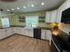 Bright kitchen with wood countertops, white cabinets, a double farmhouse sink and stainless dishwasher at 219 Magnolia Cir, Eustis, FL 32726