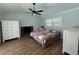 Comfortable bedroom with wood floors, ceiling fan, fireplace and light-filled windows at 219 Magnolia Cir, Eustis, FL 32726