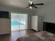 Bedroom with pool access featuring wood floors, ceiling fan, fireplace and white dressers at 219 Magnolia Cir, Eustis, FL 32726