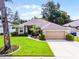 Inviting single-Gathering home showcasing lush green grass, trimmed hedges, and an attached two-car garage for convenience at 2389 Grand Poplar St, Ocoee, FL 34761