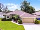 Beautiful single-story house with verdant lawn, neatly trimmed shrubs, and an attached two-car garage for parking ease at 2389 Grand Poplar St, Ocoee, FL 34761