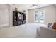 Cozy living room features light carpet, a ceiling fan, and an entertainment center, with doors leading to the backyard at 2389 Grand Poplar St, Ocoee, FL 34761
