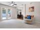 Bright living room with plush chair, carpet, and French doors leading to outdoor play area at 2389 Grand Poplar St, Ocoee, FL 34761