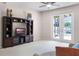 Bright living room featuring a ceiling fan, neutral carpeting, large entertainment center, and rear exit to the lanai at 2389 Grand Poplar St, Ocoee, FL 34761