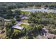 This aerial view showcases a home near a serene lake, surrounded by lush greenery and mature trees at 2450 W Lake Dr, Deland, FL 32724