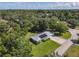 Aerial view of a single-story home with solar panels, well-maintained landscaping, and a metal roof at 2450 W Lake Dr, Deland, FL 32724