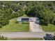 Aerial view of home featuring a metal roof, solar panels, green lawn, and three-car garage at 2450 W Lake Dr, Deland, FL 32724