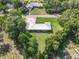Aerial view of a home showcasing its metal roof, solar panels, a well-maintained yard, and mature trees at 2450 W Lake Dr, Deland, FL 32724