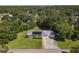This aerial view showcases a home with solar panels, lush lawns, mature trees, and a private driveway at 2450 W Lake Dr, Deland, FL 32724