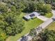 Aerial view of a single-story home with solar panels, well-maintained landscaping, and a metal roof at 2450 W Lake Dr, Deland, FL 32724