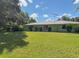 Expansive backyard with a lush lawn, mature trees, and a charming view of the property at 2450 W Lake Dr, Deland, FL 32724