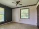 Bedroom with a ceiling fan, two windows, wallpaper accent wall, and floral trim at 2450 W Lake Dr, Deland, FL 32724