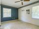Bedroom with two windows, wallpaper accent wall, floral trim, and mounted hooks at 2450 W Lake Dr, Deland, FL 32724