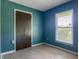 Bedroom with a closet, window, and blue patterned wallpaper at 2450 W Lake Dr, Deland, FL 32724