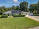 Exterior view of home featuring a metal roof, solar panels, green lawn, and three-car garage at 2450 W Lake Dr, Deland, FL 32724