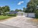 An exterior view of a home with a metal roof, solar panels, multiple garage doors, and lush landscaping at 2450 W Lake Dr, Deland, FL 32724