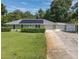 Charming single-story home with a well-manicured lawn, metal roof and three car garage at 2450 W Lake Dr, Deland, FL 32724