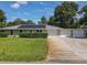 Charming single-story home with a well-manicured lawn, metal roof and three car garage at 2450 W Lake Dr, Deland, FL 32724