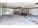 View of an open garage with concrete flooring, shelving and workspace at 2450 W Lake Dr, Deland, FL 32724