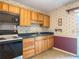 Cozy kitchen featuring light wood cabinets, black appliances, and a double basin sink at 2450 W Lake Dr, Deland, FL 32724