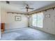 Cozy living room with a ceiling fan, large window, and neutral-colored walls and carpet at 2450 W Lake Dr, Deland, FL 32724