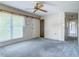 Cozy living room with a ceiling fan, large window, and neutral-colored walls and carpet at 2450 W Lake Dr, Deland, FL 32724