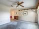 Cozy living room with a ceiling fan, large window, and neutral-colored walls and carpet at 2450 W Lake Dr, Deland, FL 32724