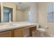 Bright bathroom features a large mirror, tiled shower, and a neutral-toned vanity and toilet at 2717 Bushman Dr, Kissimmee, FL 34746