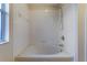 Clean bathroom with white tiled walls features a tub with shower head and a soap dish at 2717 Bushman Dr, Kissimmee, FL 34746