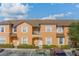 A sunny, orange two-story townhome with a brown roof, white trim, and well-maintained landscaping at 2717 Bushman Dr, Kissimmee, FL 34746