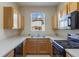 Galley kitchen featuring oak cabinets, laminate countertop, and a window view to the building exterior at 2717 Bushman Dr, Kissimmee, FL 34746