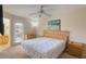 Bright main bedroom features a ceiling fan, a painting, a dresser, and a sliding glass door to a balcony at 2717 Bushman Dr, Kissimmee, FL 34746