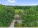 Aerial view showcases the home nestled among mature trees and surrounded by serene greenery at 302 W Rose Ln, Lady Lake, FL 32159