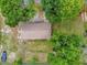 Overhead aerial view of the property shows a functional layout surrounded by mature trees at 302 W Rose Ln, Lady Lake, FL 32159