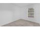 An empty bedroom with a neutral color palette is flooded with natural light from the window at 302 W Rose Ln, Lady Lake, FL 32159
