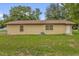 Home's rear exterior shows a fenced yard and simple design in a tranquil setting at 302 W Rose Ln, Lady Lake, FL 32159
