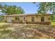 Inviting single-story home featuring an attached garage, a welcoming entrance ramp, and a manicured lawn at 302 W Rose Ln, Lady Lake, FL 32159