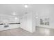 Open-concept kitchen with white cabinetry, appliances, ceramic tile flooring, and natural light at 302 W Rose Ln, Lady Lake, FL 32159