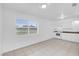 Open-concept kitchen with white cabinetry, an electric range, and ceramic tile floors at 302 W Rose Ln, Lady Lake, FL 32159