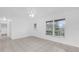 Bright living room showcasing a front door entry, new ceramic tile, and large windows at 302 W Rose Ln, Lady Lake, FL 32159
