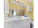 Bright bathroom with white cabinets, spacious countertops, and a large mirror with vanity lighting at 3105 Carrollton Ct, The Villages, FL 32162