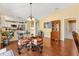 Bright dining space with view of kitchen, hardwood floors, seating for four under chandelier at 3105 Carrollton Ct, The Villages, FL 32162