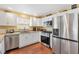 Modern kitchen with stainless steel appliances, white cabinets, granite countertops, and hardwood floors at 3105 Carrollton Ct, The Villages, FL 32162