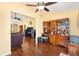 Spacious living room with hardwood floors, ceiling fans, television, and plenty of seating at 3105 Carrollton Ct, The Villages, FL 32162