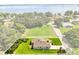 Aerial view of home with a large manicured lawn and mature trees at 321 Watershore Dr, Leesburg, FL 34748